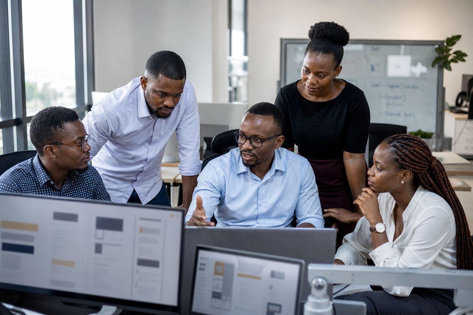 Technology team reviewing product work on screens in a contemporary African office